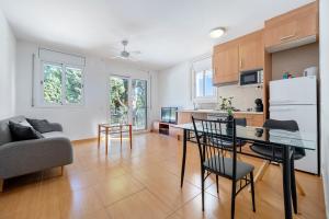 a kitchen and living room with a table and chairs at Dorada Apartment Sol in Calafell