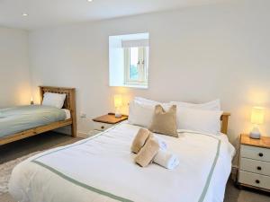 a bedroom with a large white bed with two pillows at Salton Lodge Barns in Great Edston