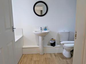 a white bathroom with a sink and a toilet at Salton Lodge Barns in Great Edston +21 photos