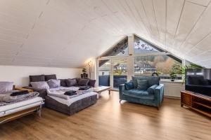 a living room with a couch and two chairs and a tv at Pistenblick in Willingen