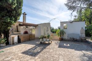 a courtyard with a house with a fireplace and a bench at Villa Massa in Polignano a Mare