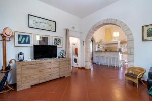 a living room with a television on a wooden cabinet at Villa Massa in Polignano a Mare