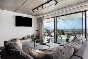 a living room with a couch and a flat screen tv at Gran Suite Horizonte in Puerto del Carmen