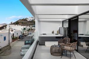 a balcony with chairs and a view of a city at Gran Suite Horizonte in Puerto del Carmen