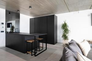 a kitchen with a black island in a living room at Gran Suite Horizonte in Puerto del Carmen