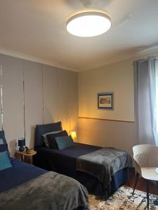 a bedroom with two beds and a large light at Quinta da Vigia in Angra do Heroísmo