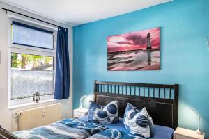 a bedroom with a bed with a lighthouse picture on the wall at Charmante 32 m² Ferienwohnung in Barth