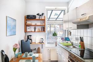a kitchen with white cabinets and a sink and a window at Charmante 32 m² Ferienwohnung in Barth