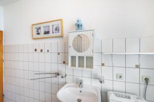a white bathroom with a sink and a mirror at Charmante 32 m² Ferienwohnung in Barth +9 photos