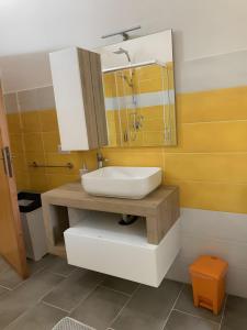 a bathroom with a sink and a mirror at Fantastico quadrilocale vista mare in Trinità d'Agultu e Vignola +19 photos