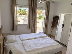 a bedroom with a bed and a large window at Casa Luzia in Miami Platja