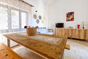 a living room with a wooden table with a basket of flowers at Fantastico quadrilocale vista mare in Trinità d'Agultu e Vignola