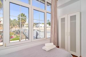 a bedroom with a bed and large windows at Nerja Vacaciones Apartamentos in Nerja +259 photos