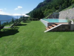 a large yard with a swimming pool and chairs at Löchlerhof in Ritten