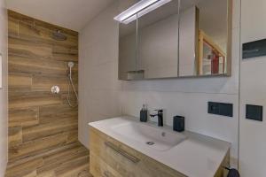 a bathroom with a sink and a mirror at Luxus Chalet Landhaus Rachelblick in Eppenschlag +26 photos