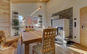 a kitchen and dining room with a table and a refrigerator at Luxus Chalet Landhaus Rachelblick in Eppenschlag
