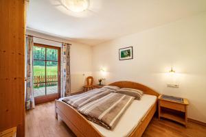 a bedroom with a bed and a window at Rieglhof Apartment Geiernest in Curon Venosta