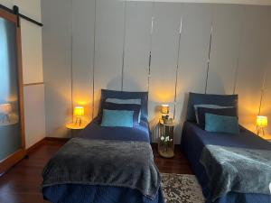 two beds in a room with two lamps at Quinta da Vigia in Angra do Heroísmo