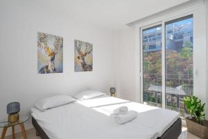 a white bedroom with two beds and a window at Penthouse Banderas with own pool in La Cala de Mijas +13 photos
