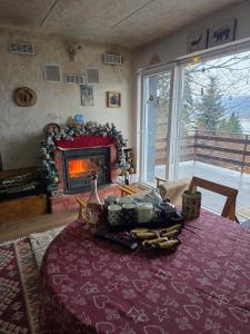 a living room with a table with a fireplace at Villa Freddie Mavrovo - Lakeview House in Mavrovo