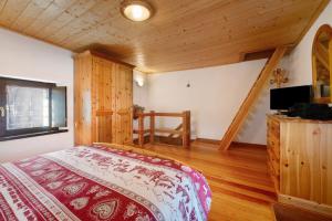 a bedroom with a bed and a television in a room at Petite Maison des Alpes in Morgex