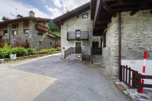 a stone building with a balcony on the side of it at Petite Maison des Alpes in Morgex
