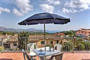 a table with a blue umbrella on a patio at Casa Consuelo App. 1 (trilocale) in Capoliveri
