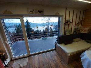 a room with a large window with a view of a mountain at Villa Freddie Mavrovo - Lakeview House in Mavrovo
