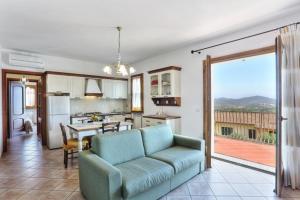 a living room with a couch and a kitchen at Casa Consuelo App. 1 (trilocale) in Capoliveri