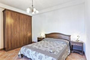 a bedroom with a bed and a wooden cabinet at Casa Consuelo App. 1 (trilocale) in Capoliveri
