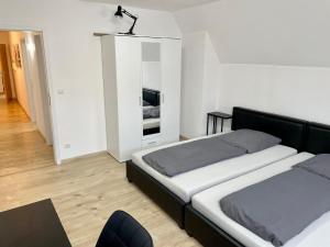 a bedroom with two beds and a mirror at Ferienwohnung Khorsandi Zwei in Coburg +7 photos