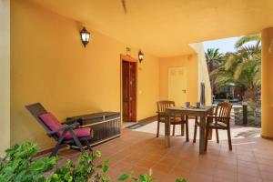 a dining room with a table and chairs on a patio at Oasis Bahia Fronte Piscine in Corralejo