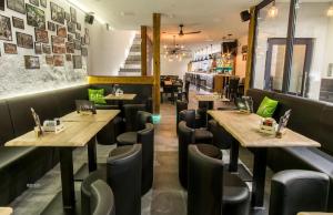 a restaurant with wooden tables and black chairs at Ferienwohnung Khorsandi Zwei in Coburg