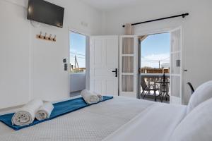 a white bedroom with a bed with towels on it at 08 Double room Perivolos beach in Santorini