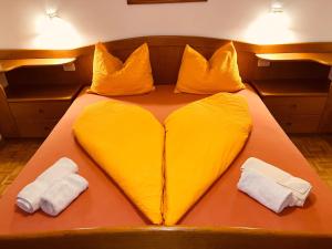 a large yellow bed with two white towels on it at Residence Zirmer Wohnung Erde in Castelrotto