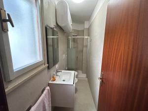 a small bathroom with a sink and a shower at Villaggio Olimpia in Bibione +29 photos