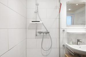 a white bathroom with a shower and a sink at Ferienwohnung Windradblick in Schonach +33 photos