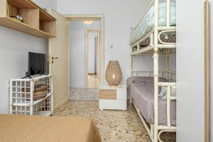 a bedroom with two bunk beds and a television at Appartamento del corso in Olbia