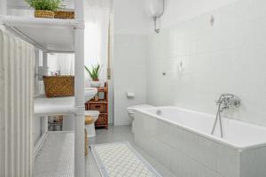 a white bathroom with a tub and a sink at Appartamento del corso in Olbia +15 photos