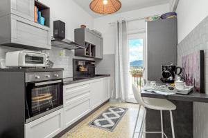 a kitchen with a stove and a counter with a chair at Appartamento del corso in Olbia