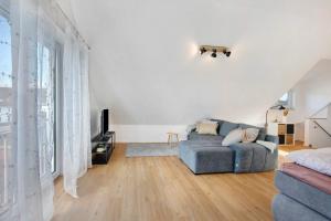 a living room with a blue couch and a large window at Dachstudio am Donau Rad Weg in Tegernheim