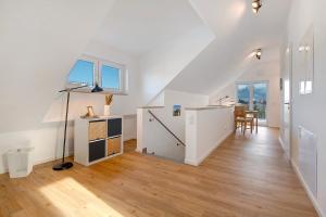 an attic room with white walls and wooden floors at Dachstudio am Donau Rad Weg in Tegernheim