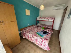 a small bedroom with a bed and a dresser at Villaggio Olimpia in Bibione