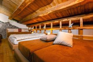 three beds in a room with wooden ceilings at Bosco Magaudo - Casa U Parmento in Linguaglossa