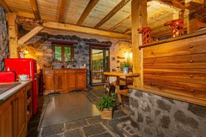 a kitchen with wooden cabinets and a red refrigerator at Bosco Magaudo - Casa U Parmento in Linguaglossa +29 photos