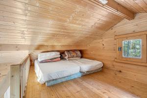 a bed in a log cabin with a window at Chalet Le Mazet in Les Prats