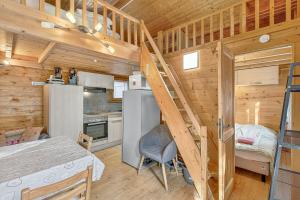 a small kitchen with a staircase in a tiny house at Chalet Le Mazet in Les Prats
