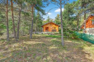 a wooden cabin in the woods with trees at Chalet Le Mazet in Les Prats