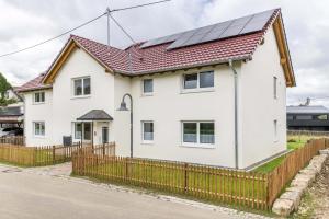 a white house with solar panels on its roof at Ferienwohnung "Haus Kellenburg" in Albstadt