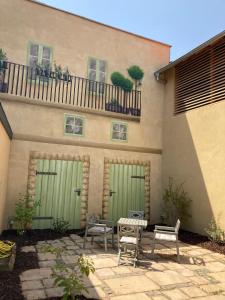 a building with two green doors and a patio at Ferienhaus Monteverde in Meddersheim